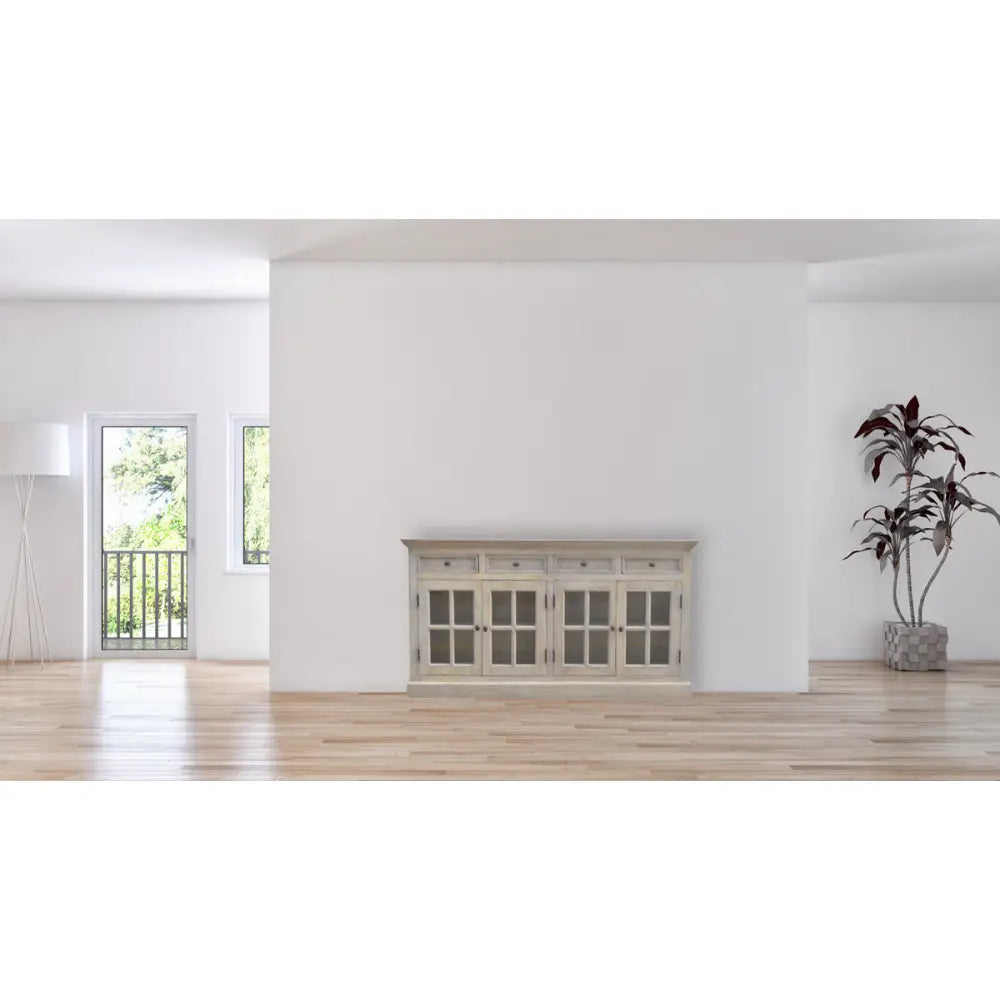 Stone Acid Wash Glazed Sideboard made from solid mango wood with four drawers and four glazed doors. Sideboard positioned on the wall of a living room